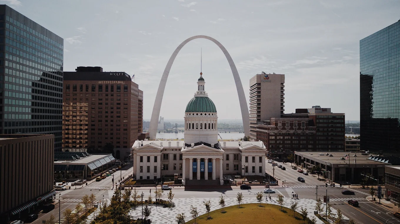 Historic courthouse, Arch, tall buildings, clear sky.