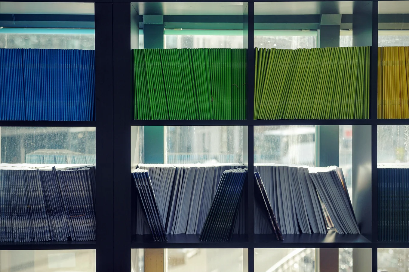 Shelves with stacked blue, green, yellow folders.